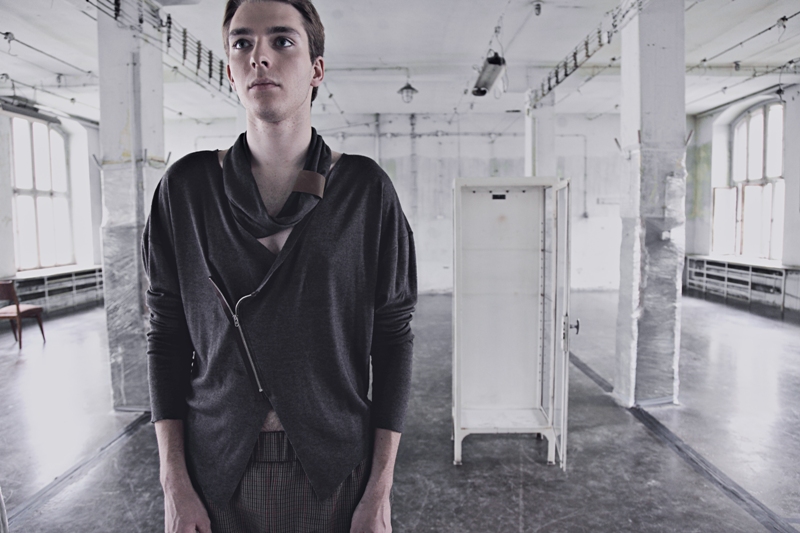 Model in an asymmetric zipped knit with a draped collar